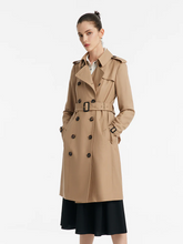 a lady in a camel double-breasted trench coat